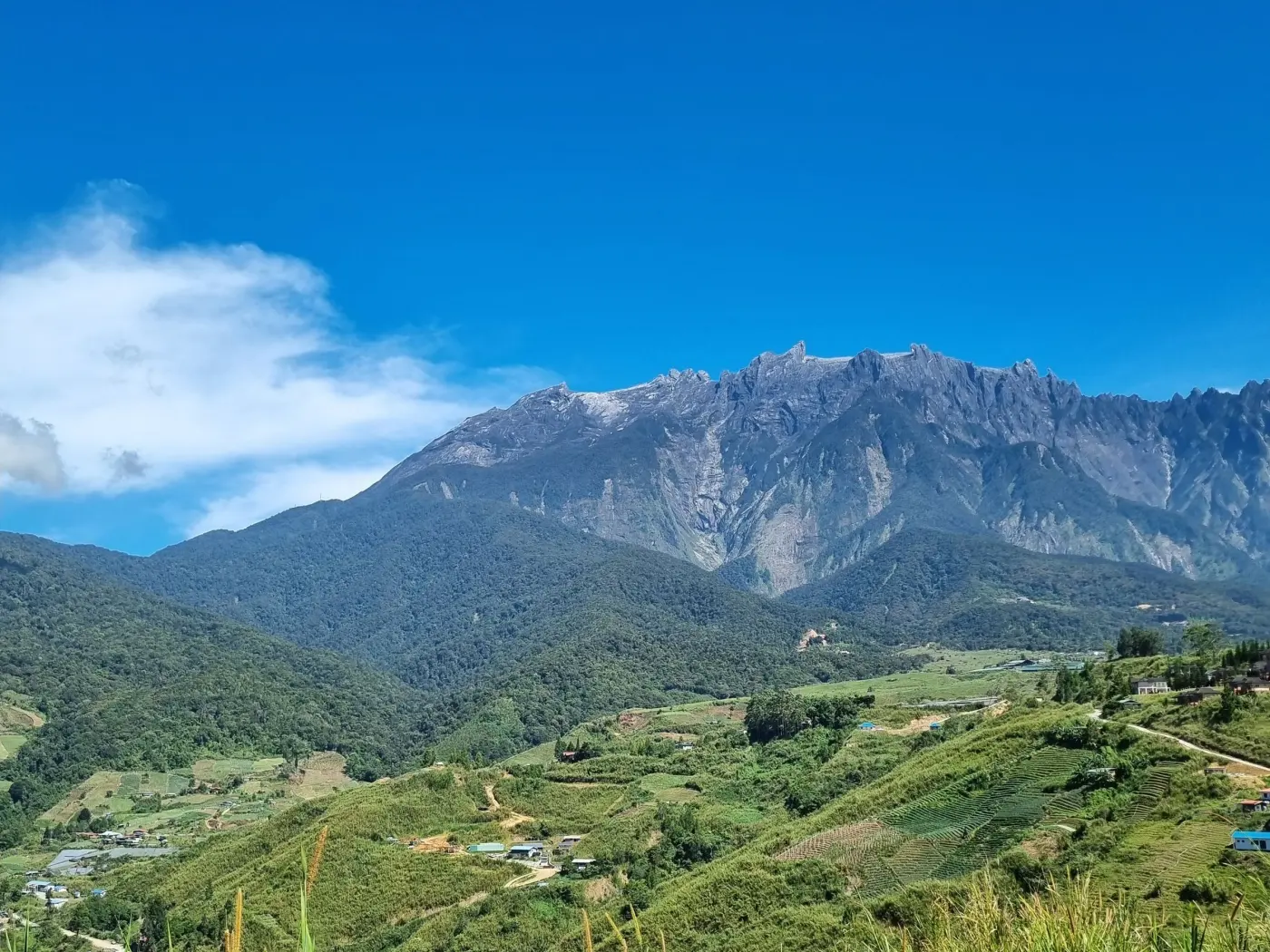 Banjaran Gunung Kinabalu dilihat merentasi tanah tinggi hijau Kundasang
